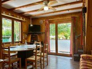 a dining room with a table and chairs and a tv at Horizon Nature - WIFI - Jardin in Jausiers