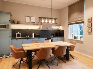a kitchen with a wooden table and chairs at Getaway In East Frisia Elegant Lakeside Apartment in Friedeburg