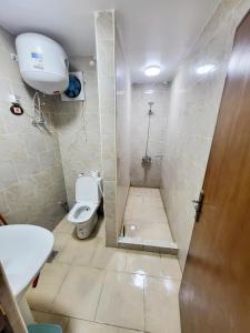 a small bathroom with a toilet and a shower at Palmera Chalets Best Vacation Group in Ain Sokhna
