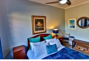 a bedroom with a bed with blue and white pillows at RR001 Robbins Road - A home away from home in Ballito +14 photos