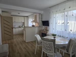 a kitchen and dining room with a table and chairs at Villa Magnolia in Ipoteşti