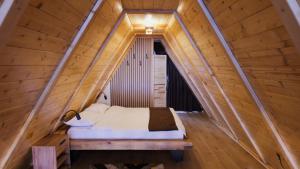a bedroom in a wooden house with a bed at Vălari Frame in Păltiniş +21 photos