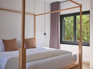 阿查拉维Lena Mare Boutique Hotel的一间卧室设有天蓬床和窗户。