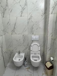 a white bathroom with a toilet and a sink at Flat in Orikum Beach in Orikum +5 photos