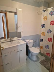 a bathroom with a toilet and a sink and a shower curtain at apartamento los montes in Ruidera