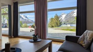 a living room with a large window with mountains at The House of Aurora I in Tromsø