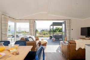 a living room with couches and a table and a tv at Seaham Hall and Serenity Spa in Seaham