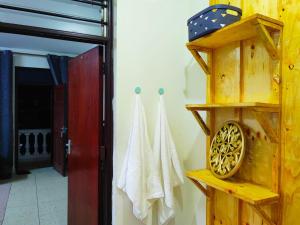 baño con estante de madera y puerta en Terry Homes, en Mombasa