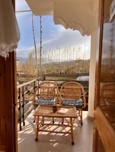 due sedie e un tavolo su un balcone con vista di Mountain muse bnb a Leh
