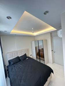 a bedroom with a large black bed and a ceiling at RUBİN Residence in Alanya +4 photos
