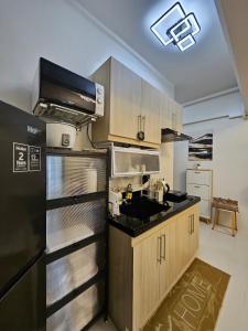 a kitchen with wooden cabinets and a black refrigerator at Oceanside Escape in Panglao Bohol in Panglao Island +21 photos