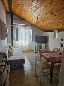 a living room with a bed and a table with a tableablish at Apartment Zdenka in Dinjiška