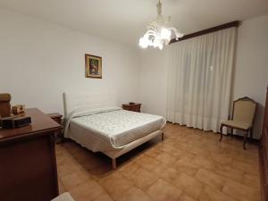 a bedroom with a bed and a chandelier at Gigi's House in Colico