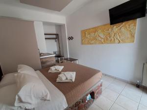 una camera da letto con un letto con due asciugamani sopra di Villa Nektaria a Perissa