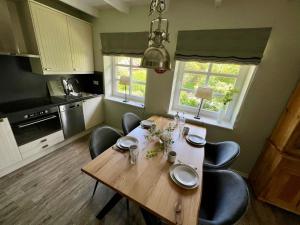 a kitchen with a wooden table and some chairs at FERIENWOHNUNG HOLST – SYLT (Braderup) in Braderup