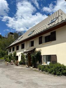 a large white building with a roof at Auberge de Pra-Loup in Pra-Loup