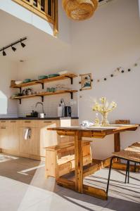 a kitchen with a wooden table and a wooden bench at Bujanie w sitowiu in Wyszowate +87 photos
