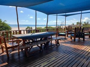 a picnic table on a deck with a view of the beach at Seadeck, Barra Mozambique in Inhambane +17 photos