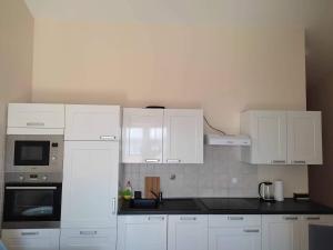 une cuisine avec des armoires blanches et des comptoirs noirs dans l'établissement Blue Horizon - 400m from the Sea!, à Dramalj 5 autres photos