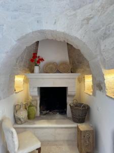 マルティナ・フランカにあるTrulli e Frascheのリビングルーム(石造りの暖炉、椅子付)
