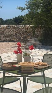 マルティナ・フランカにあるTrulli e Frascheのパンと花の載ったトレイが置かれたテーブル +12枚の写真