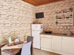 a kitchen with a refrigerator and a tv on a brick wall at APARMENTS Elina in Potamiá