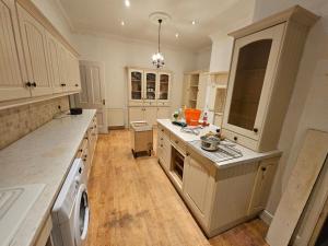 une grande cuisine avec des placards blancs et un lave-linge/sèche-linge dans l'établissement Grimsby Central Luxury 2 Bedrooms, Pelham 1, à Great Coates