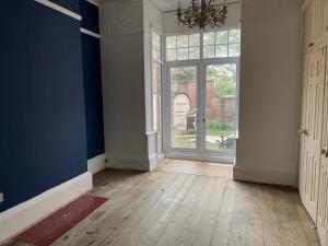 une pièce vide avec une grande fenêtre et des murs bleus dans l'établissement Grimsby Central Luxury 2 Bedrooms, Pelham 1, à Great Coates