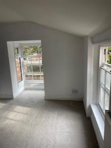 une pièce vide avec des murs blancs et 2 fenêtres dans l'établissement Grimsby Central Luxury 2 Bedrooms, Pelham 1, à Great Coates