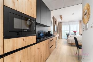 Una cocina con TV de pantalla plana y un dormitorio. en Your Holidays Infinity B413, en Międzyzdroje