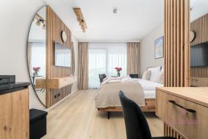 Un dormitorio con una cama grande y un espejo. en Your Holidays Infinity B413, en Międzyzdroje