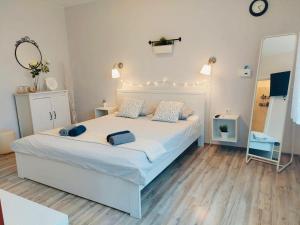 a bedroom with a large white bed with a mirror at Kosovic Family House in Medulin