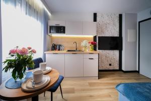 kuchnia i jadalnia ze stołem w pokoju w obiekcie Apartamenty i Pokoje Złotobrzeg w Sarbinowie +29 zdjęć