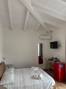 a white bedroom with a bed and a table at Domo Il Tramonto Giba in Giba