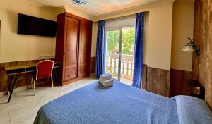 a bedroom with a bed and a desk and a window at Hotel Portofino in Empuriabrava