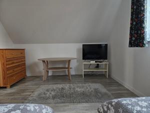 a living room with a table and a tv at Chata nad Rzeką in Lipusz
