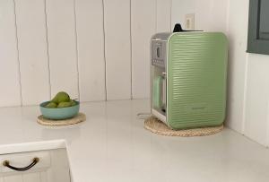un réfrigérateur vert posé sur un comptoir à côté d'un bol de fruits dans l'établissement Ληγάτο Cottage House, à Áyios Pétros