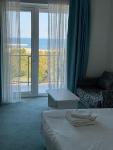 ein Hotelzimmer mit Bett und Blick aufs Meer in der Unterkunft Mediterranean Apartments at Blaxy, Olimp in Olimp