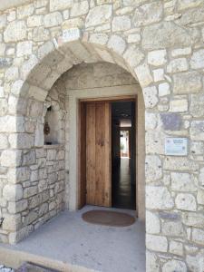 an entrance to a stone building with a wooden door at Moon Alaçatı adults only in Çeşme