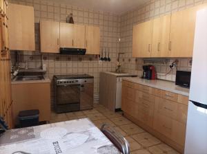 a kitchen with wooden cabinets and a stove top oven at Casa Rural RosaVera in Ossa de Montiel +49 photos