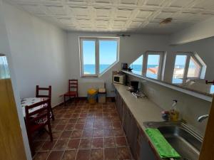 a kitchen with a sink and a counter with windows at Vila Ilinca in Agigea +22 photos