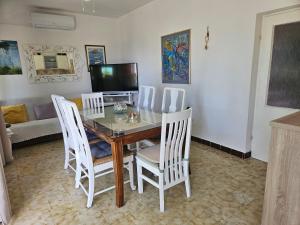 a dining room with a glass table and white chairs at Apartment Zdenka in Dinjiška +54 photos