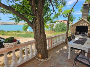 a tree on a balcony with a table and a fireplace at Apartment Zdenka in Dinjiška