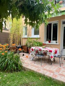 a patio with a table and chairs in a yard at Échoppe bordelaise avec jardin in Talence