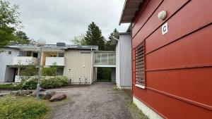 a red and white building with a driveway at Oulu Modern 2BR with Sauna, Patio and Parking, 10 min to Center in Oulu