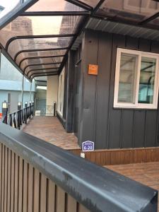 Un edificio con una pasarela de madera con un cartel en ella. en Laon Haje, Joyful Tomorrow, en Buyeo