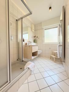 a white bathroom with a shower and a sink at Ferienwohnung direkt am Wasser in Lahnstein