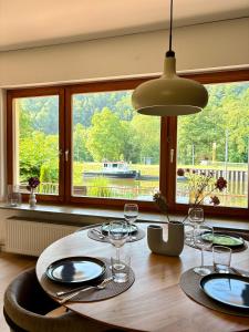 a dining room table with glasses and a large window at Ferienwohnung direkt am Wasser in Lahnstein