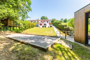 a backyard with a bench and a house at Villa Basoa - Villa avec piscine à 10 min plages in Bassussarry