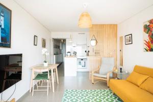 ein Wohnzimmer und eine Küche mit einer Couch und einem Tisch in der Unterkunft Nouveau T2 Horizon Vue Mer Palavas in Palavas-les-Flots + 17 Fotos
